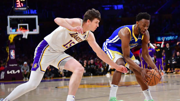Lakers guard Austin Reaves tries to steal the ball from Warriors guard Andrew Wiggins.